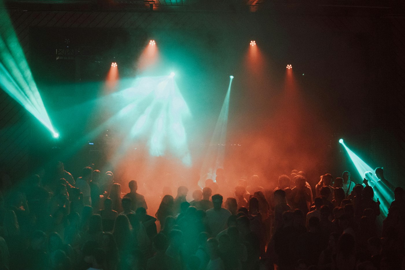 Dansende mensen onder blauw en paars podiumlicht