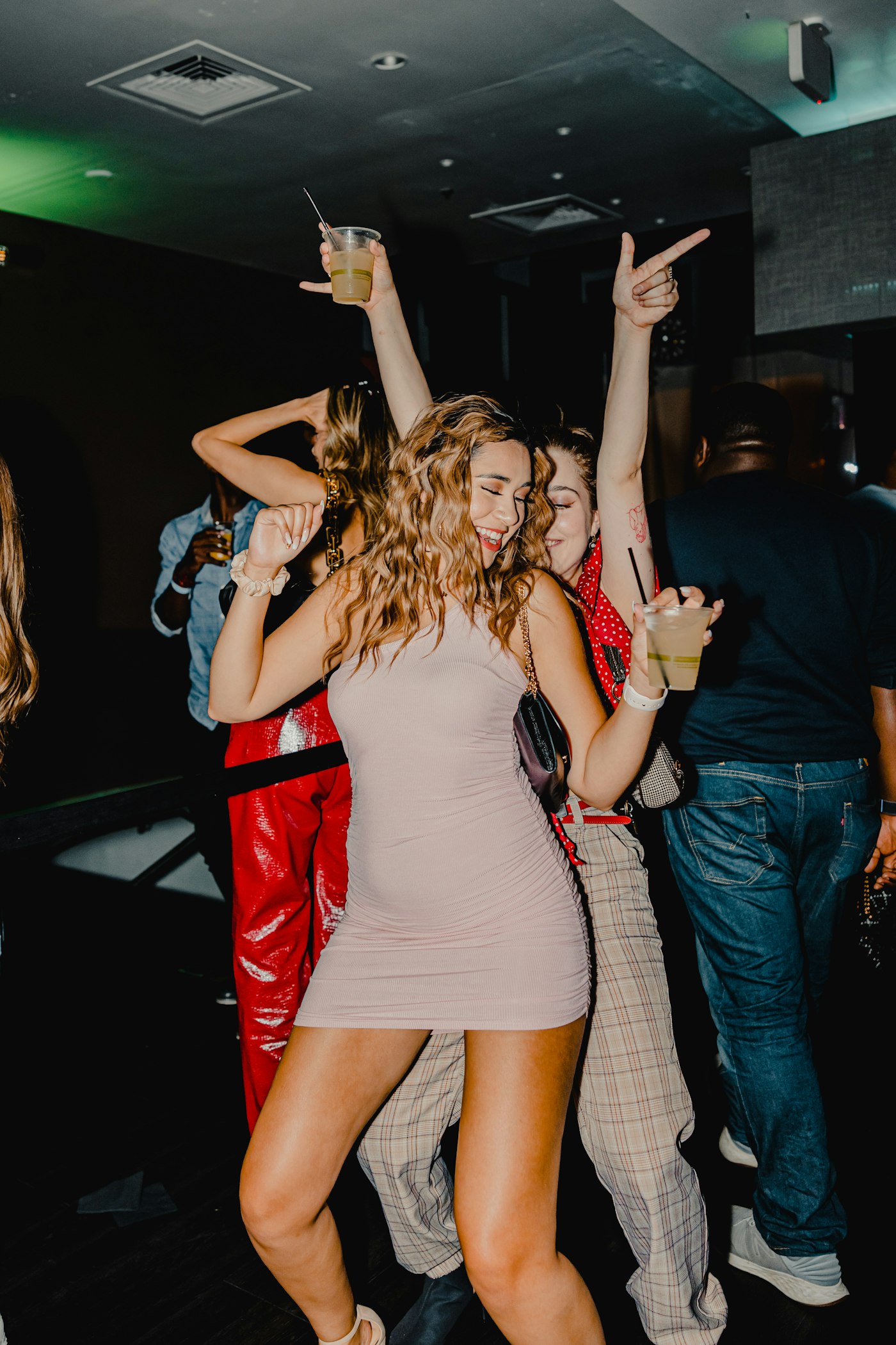 Feestgangers met drankjes in een donkere zaal